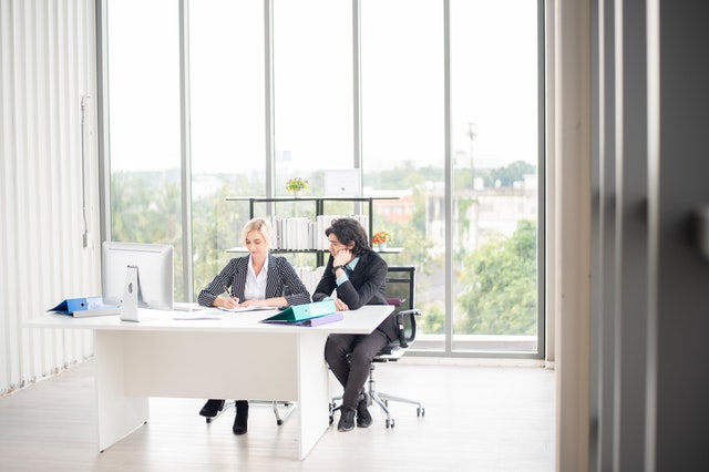 two people at a desk writing